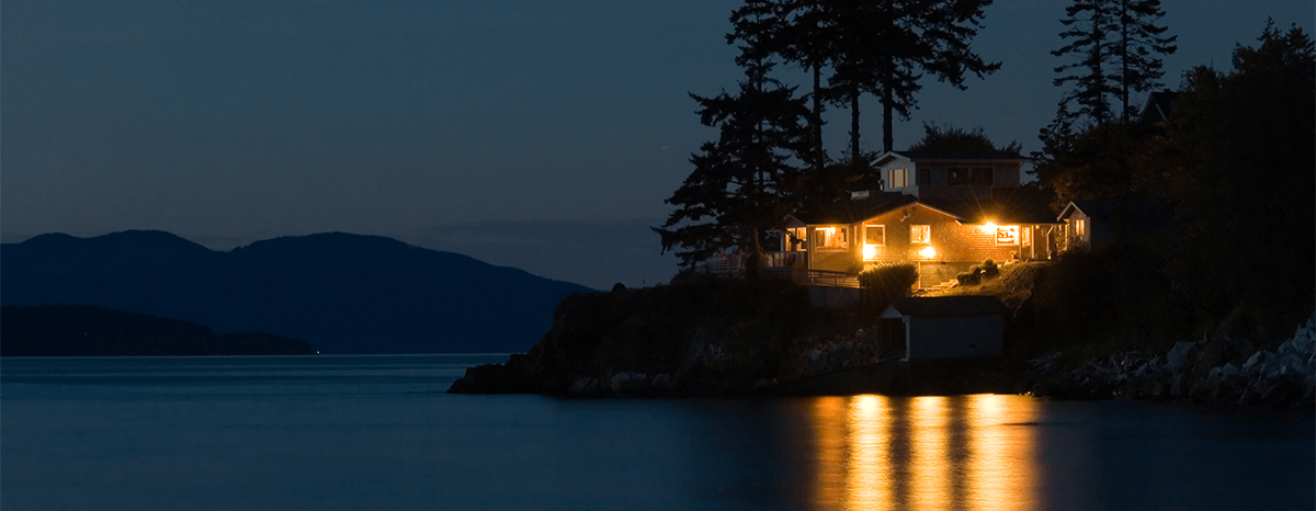Lakeside home illuminated at dusk